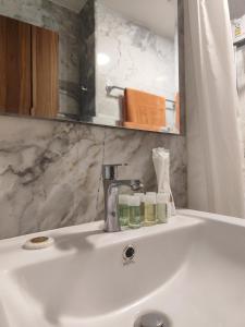 a bathroom sink with a faucet and two jars on it at Уютная студия в жилом комплексе в заповедном уголке Пхукета in Ban Mai Salae