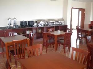 a restaurant with tables and chairs and a kitchen at GreenTree Inn Weihai Port in Weihai