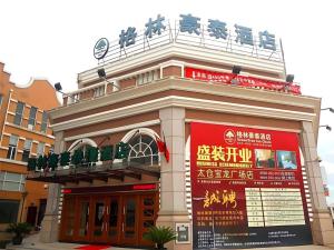 a building with a sign on the side of it at GreenTree Inn Taicang Baolong Square Hotel in Taicang