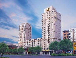 a tall building with a clock on top of it at Anshan Camilla Business Hotel in Anshan