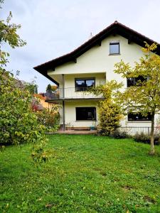 a white house with a balcony and a yard at Nanas-Auszeit in Rothenbuch