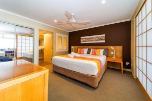 Luxury 2 Bedroom Apartment Beach Views Pool في Urangan: غرفة نوم بها سرير كبير وخزانة