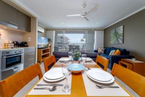 Luxury 2 Bedroom Apartment Beach Views Pool في Urangan: مطبخ وغرفة طعام مع طاولة وكراسي