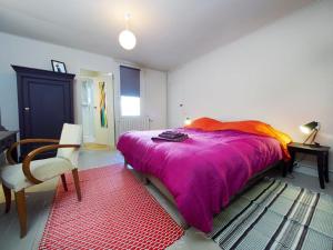 - une chambre avec un grand lit et une couverture violette dans l'établissement Chez Nolwenn, à Quimper