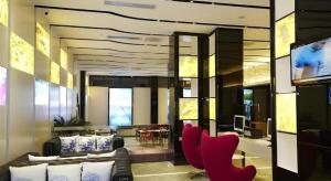 a living room with red chairs and a television at LAVANDE Hotel Dalian Huanan Square North Railway Station in Dalian