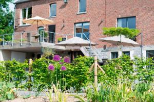 un edificio con patio e ombrelloni in giardino di Gilles De Ver a Verre
