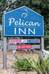 a blue sign for a paltzim inn with several signs at Pelican Inn in Monterey
