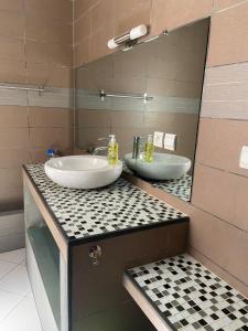 a bathroom with two sinks and a mirror at Appart Cozy Ivandry dans villa in Antananarivo