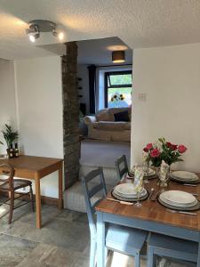 a living room with a table and a dining room at Character Cottage in Usk in Usk