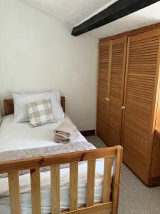 a bedroom with a bed and a wooden cabinet at Character Cottage in Usk in Usk