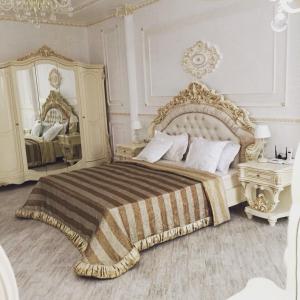 a bedroom with a bed and a dresser at Hotel Klassik in Orsk
