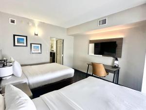 a hotel room with two beds and a flat screen tv at Comfort Inn & Suites Calhoun South in Calhoun