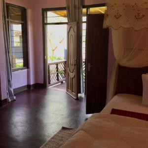 a bedroom with a bed and a door to a balcony at LIMAS Camp Mikumi in Mikumi