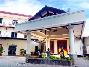 a large white building with a pavilion at Puri Mega Hotel in Jakarta