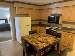 a kitchen with a table and a white refrigerator at Wingate by Wyndham Utica in Utica +33 photos