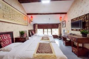 a large room with four beds and a desk at Pingyao Yufengheng Hotel in Pingyao