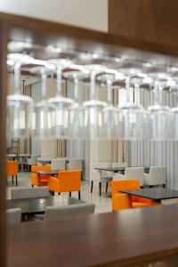 a dining room with tables and chairs and lights at Top Cloud Hotel Iksan in Iksan