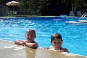 twee jonge jongens in een zwembad bij Kennebunk Gallery Motel and Cottages in Kennebunk