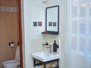 a bathroom with a sink and a mirror and a toilet at DeeHomes in Eldoret
