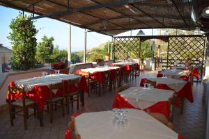 a restaurant with tables and chairs with red table cloth at B&B Collemare in Drapia +59 photos