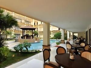 un resort con piscina, tavoli e sedie di Yusro Hotel Restaurant & Convention a Jombang