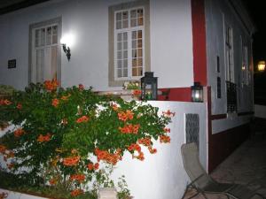 una casa blanca con un arbusto con flores naranjas en Quinta de Sao Filipe en Setúbal