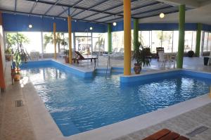 a large pool with blue water in a building at Hotel De Las Artes in Termas de Río Hondo