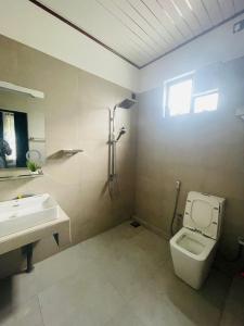 a bathroom with a toilet and a sink at Geeth Wild Resort in Tanamalwila +15 photos