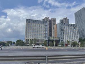 a parking lot with two tall buildings in a city at Lavande Hotel Shenzhen Pingshan High-Speed Railway Station Longdong Metro Station in Shenzhen