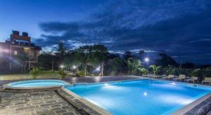 una grande piscina di notte di Center Park Resort a Sauraha