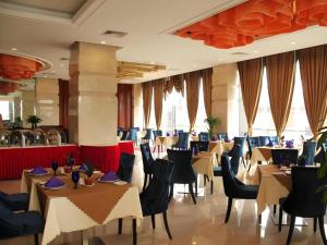 restauracja ze stołami i krzesłami w pokoju w obiekcie Foshan Nanhai Huifeng Holiday Hotel w mieście Foshan