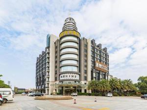 duży budynek z wieżą na szczycie w obiekcie Foshan Nanhai Huifeng Holiday Hotel w mieście Foshan