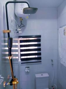 a blue bathroom with a hair dryer and a toilet at Jade Luxe 2 Bedroom Apartment in Agbor