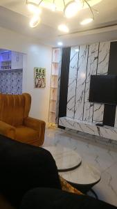 a living room with a couch and a tv at Jade Luxe 2 Bedroom Apartment in Agbor