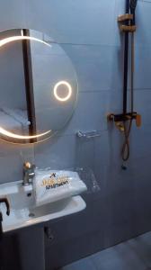 a bathroom with a mirror and a white sink at Jade Luxe 2 Bedroom Apartment in Agbor +7 photos