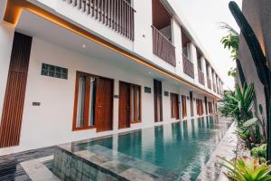 a swimming pool in the courtyard of a house at Royal Sweet By Sika in Canggu