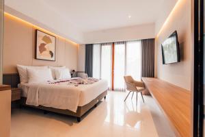 a hotel room with a bed and a chair at Royal Sweet By Sika in Canggu +21 photos