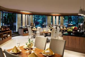 a dining room with tables and chairs in a restaurant at eL Hotel Kartika Wijaya Batu in Malang