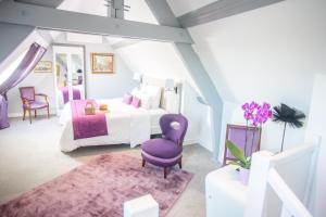 - une chambre avec un lit et une chaise violette dans l'établissement Hotel Spa - Au Charme Rabelaisien, à Amboise