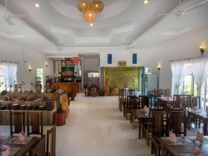 a restaurant with tables and chairs in a room at Sambopich Chenla Hotel in Kompong Thom