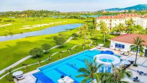an aerial view of a resort with a pool and a golf course at Sono Belle Haiphong in Hai Phong