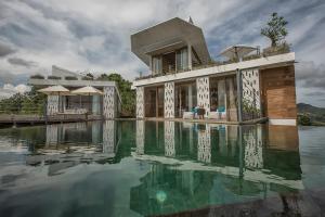 a house with a swimming pool in the water at Seven Havens Residence in Selong Belanak