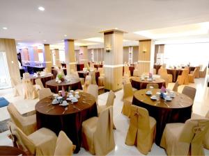 a dining room with tables and chairs in a room at Hotel Grand Permata Hati in Banda Aceh