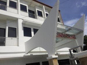 a white building with a building with a window at OPRISS HOTEL in Parapat