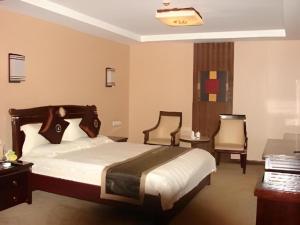 a hotel room with a bed and two chairs at Wutaishan Wufeng Hotel in Wutai