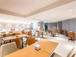 an empty cafeteria with tables and chairs at City Comfort Inn Nanning Railway Station Guangxi University in Nanning