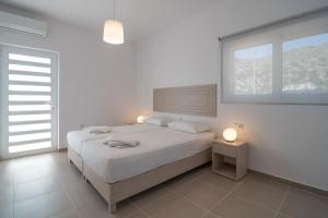 パレオコラにあるVilla-Palaiochoraの白いベッドルーム(ベッド1台、窓付)