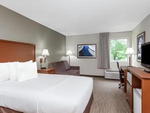 a hotel room with a large bed and a desk at Days Inn Springfield South in Springfield