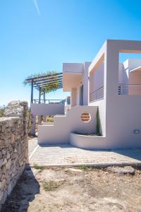 une maison blanche avec un escalier et un mur dans l'établissement Villa-Palaiochora, à Paleóchora