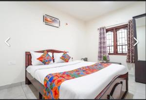 a bedroom with a large bed and a window at SS Holiday Homes in Yenūr